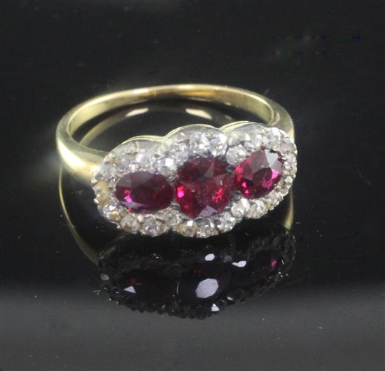 A gold, ruby and diamond triple cluster ring, size K.